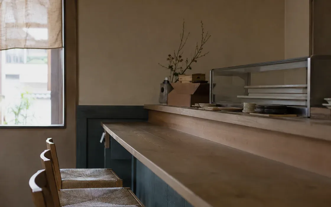 開店前の飲食店の店内。カウンターと椅子が整えられている。
